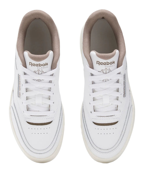 A pair of white, lace-up low top sneakers with a tan sock liner, viewed from above.