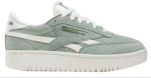 A low top light green sneaker with white laces and a white stripe that has the text "Reebok" on it, atop a thick white sole.