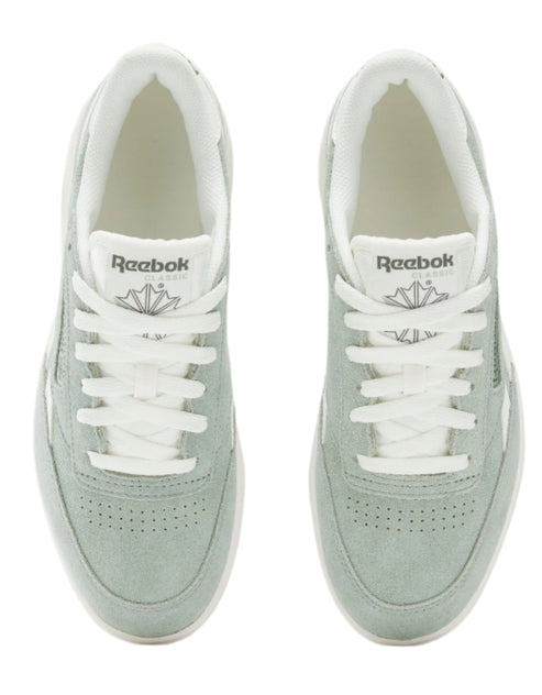 Two mint green suede sneakers with white laces. The sneakers each have the word "Reebok" and a leaf logo on the tongue.