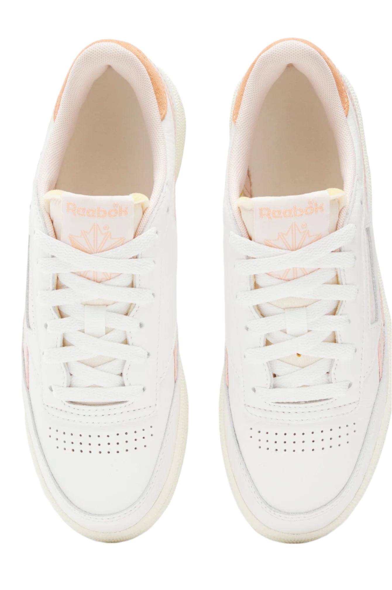 Top-down view of a pair of white sneakers with peach detailing and white laces.