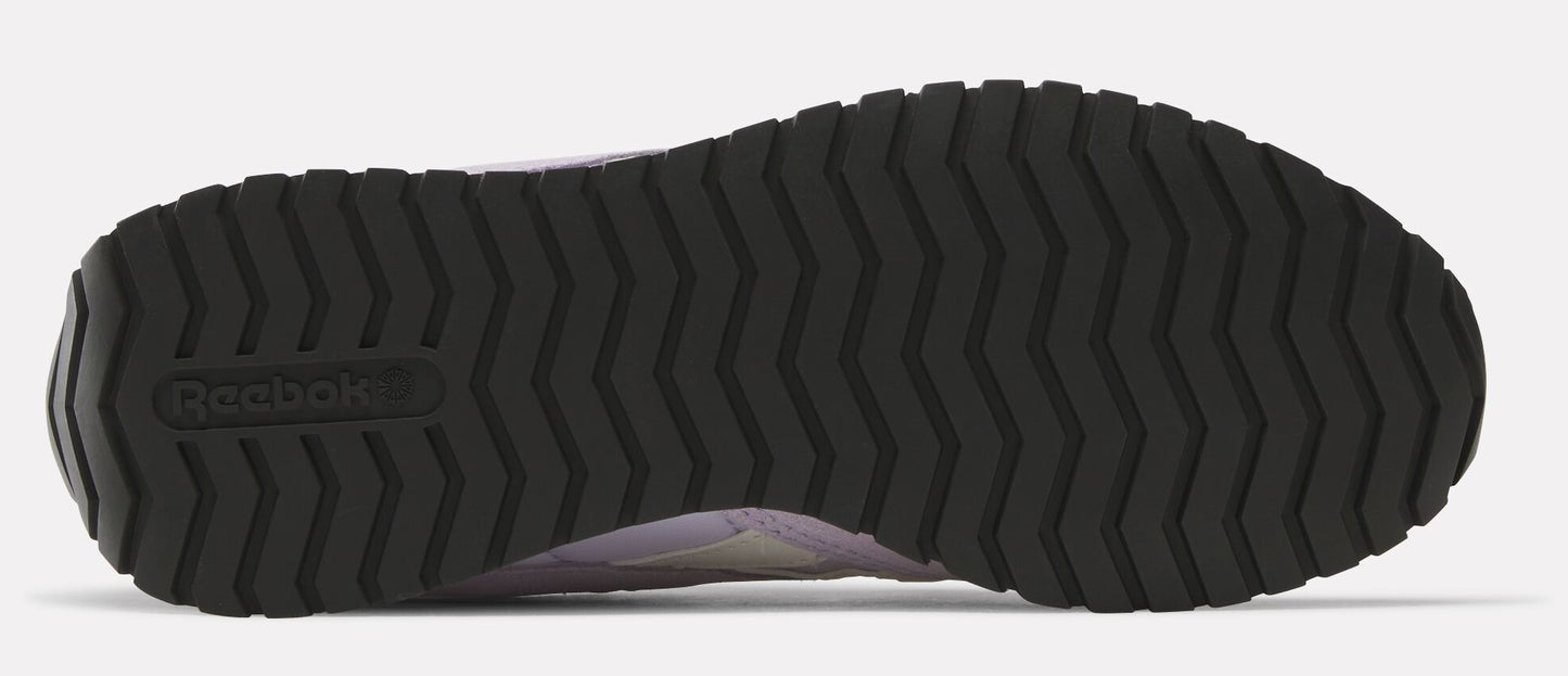The bottom view of a sneaker featuring a black, deeply treaded sole with the Reebok logo near the heel.