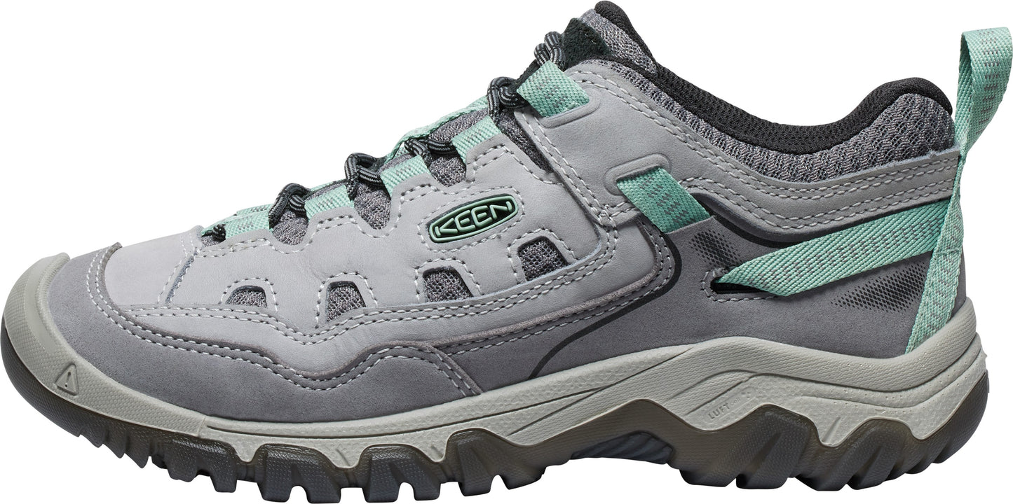 A light grey hiking shoe with teal accents, mesh detailing, a thick rubber outsole with deep lugs, and KEEN logo on the side.