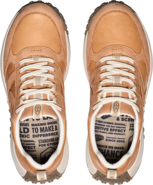 Overhead view of tan leather sneakers with white laces and soles.