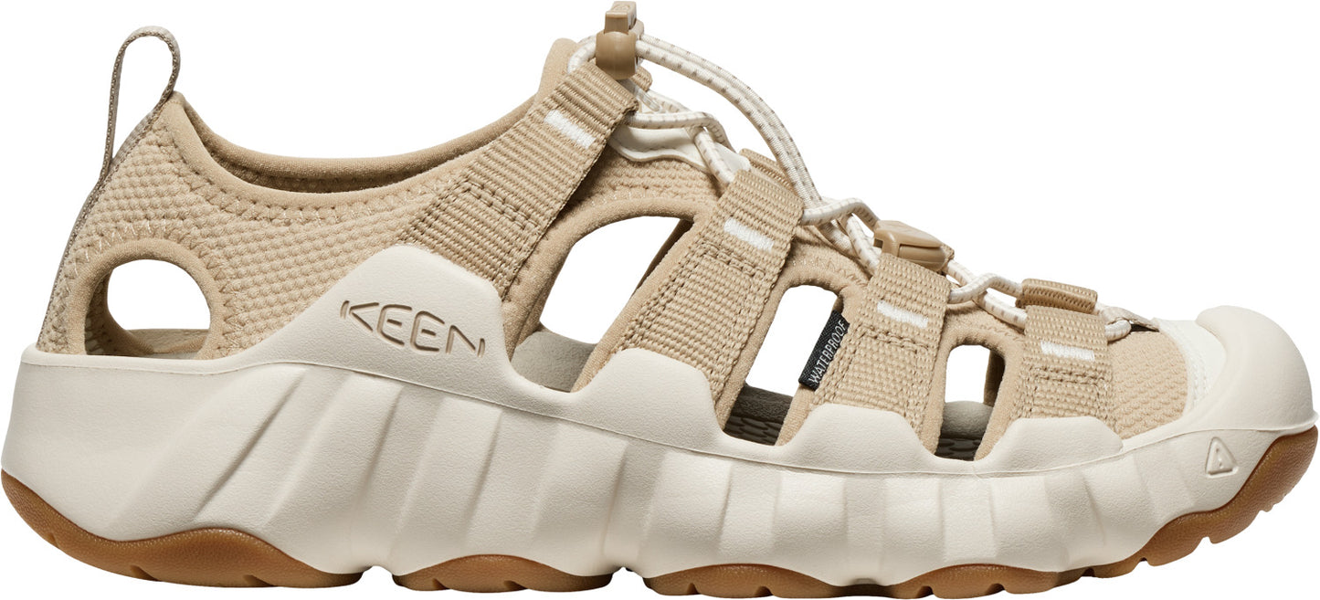 A beige KEEN sandal with adjustable straps and a white rubber toe cap.