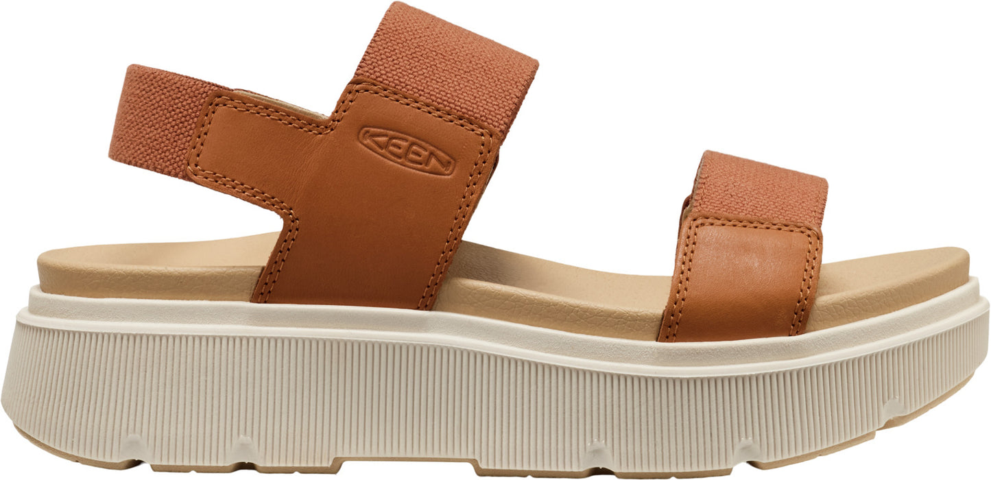 A tan sandal with thick, white platform soles and elastic straps.