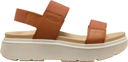 A tan sandal with thick, white platform soles and elastic straps.