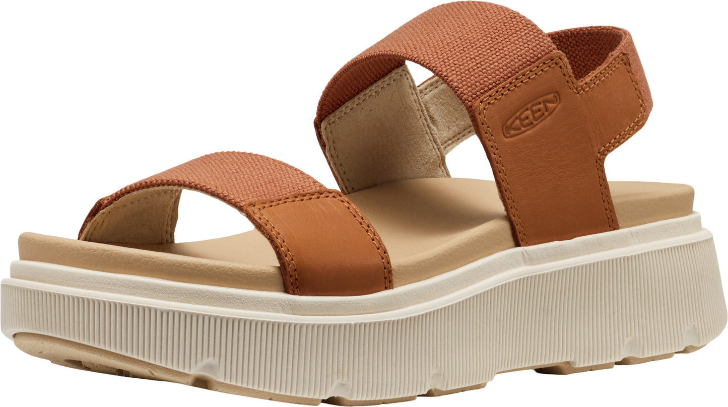 A platform sandal with tan elastic straps and a white platform sole with visible tread.