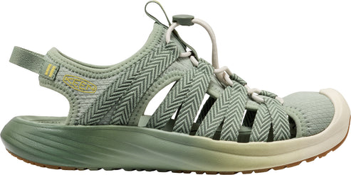 A light green sandal with a white sole and adjustable straps.