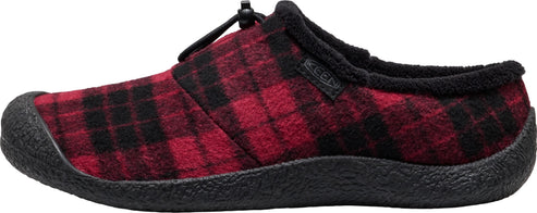 A slip-on slipper with a red and black plaid felt upper, a black fleece-lined collar, a black rubber toe cap, and a textured black rubber sole, featuring a small black bungee-style lacing adjustment toggle at the instep with a small black tag reading KEEN on the side.