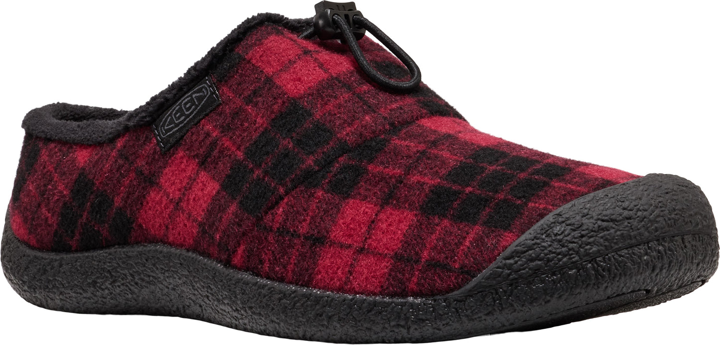 A slip-on shoe with a red and black plaid fabric upper, black fleece lining, black rubber toe cap and sole, and a black bungee cord cinch system on the top.