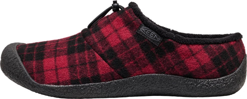 A slip-on shoe featuring a red and black plaid fleece-like upper, a thick black textured rubber sole, a fuzzy black inner lining, and a toggle-style drawstring closure on top with a KEEN tag on the side.