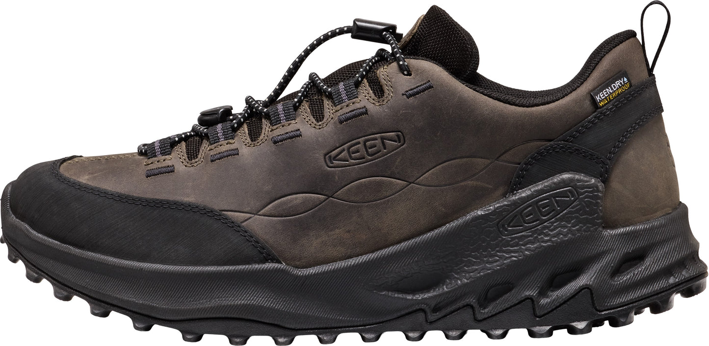 A brown KEEN waterproof hiking shoe with a black rubberized toe cap, a black toggle lace system, and a black textured midsole with a rugged lugged outsole.