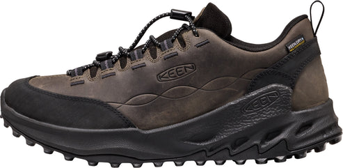 A brown KEEN waterproof hiking shoe with a black rubberized toe cap, a black toggle lace system, and a black textured midsole with a rugged lugged outsole.