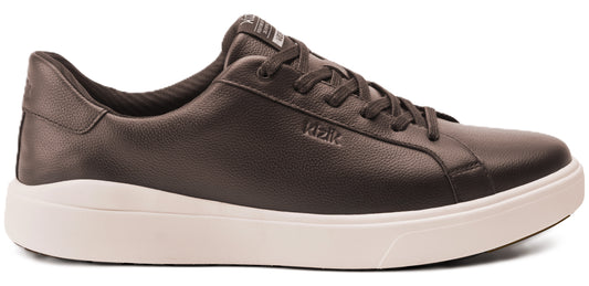 A brown leather sneaker with white soles and the word "RIZIK" printed on its side.