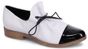 A white and black slip-on shoe with dark lace.