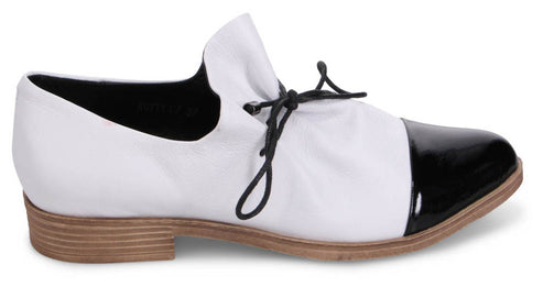 White and black dress shoe with low wooden heel and lace-up closure.