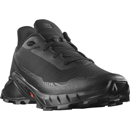 Black trail running shoe with low profile and aggressive tread pattern.