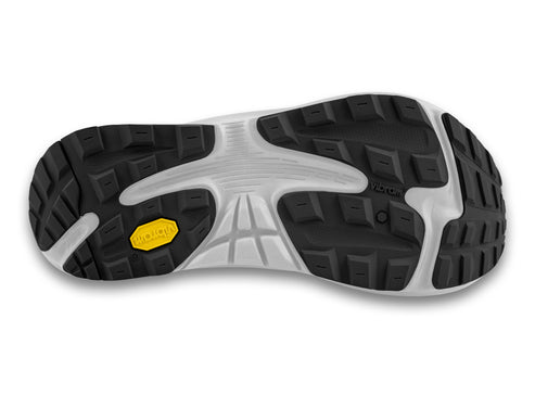 A running shoe's Vibram sole, showing black treads and a yellow logo.