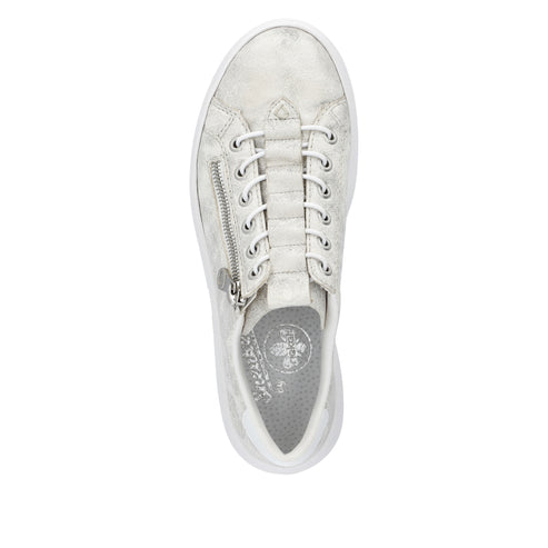 Overhead view of a white sneaker with white laces and a silver zipper.