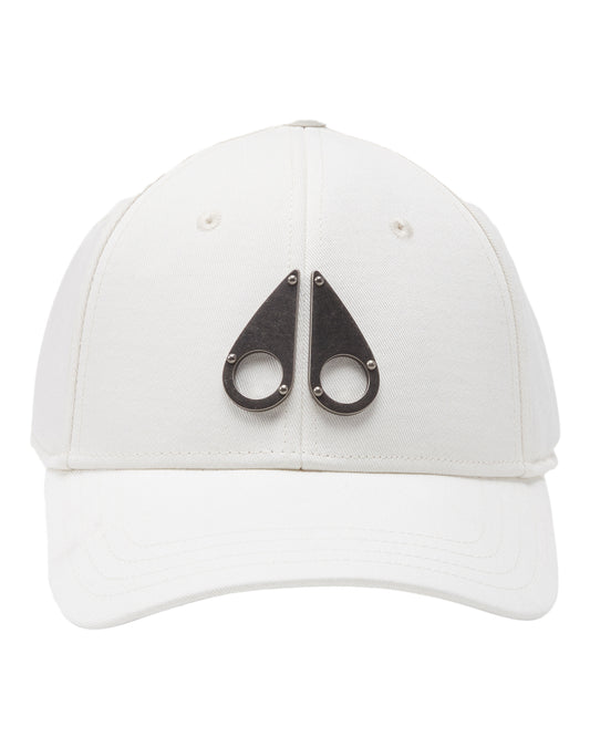 White baseball cap with two metal teardrop shapes with circles and rivets.