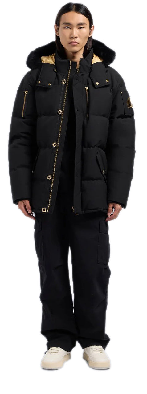 A person wearing a black parka, black pants, and cream-colored sneakers.