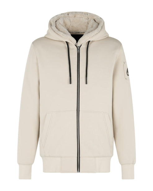 Beige hooded sweatshirt with a zipper closure, two pockets, and a logo patch on the sleeve.