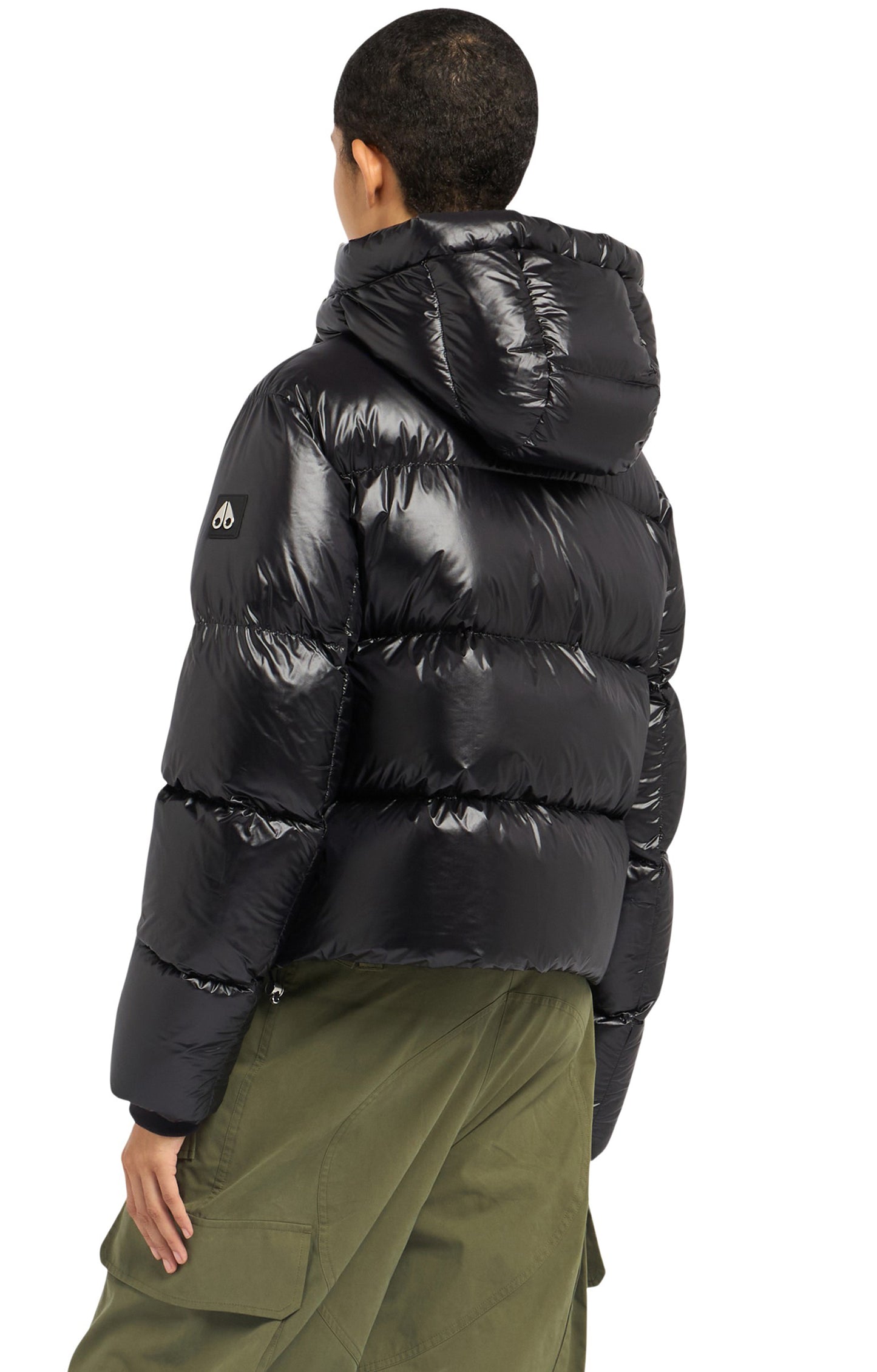 Back view of a person wearing a shiny black puffer jacket with hood.