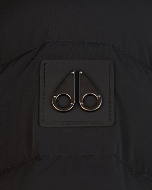 Close-up of a black square patch with a metal logo of two moose silhouettes.