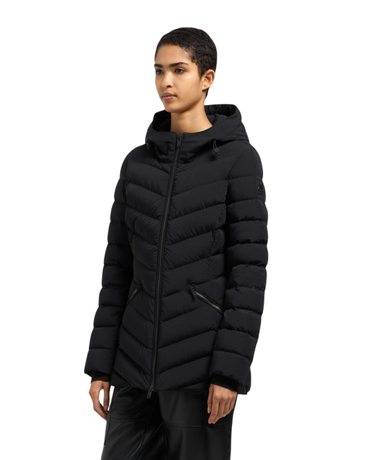 A woman wears a fitted, black puffer jacket with a hood.
