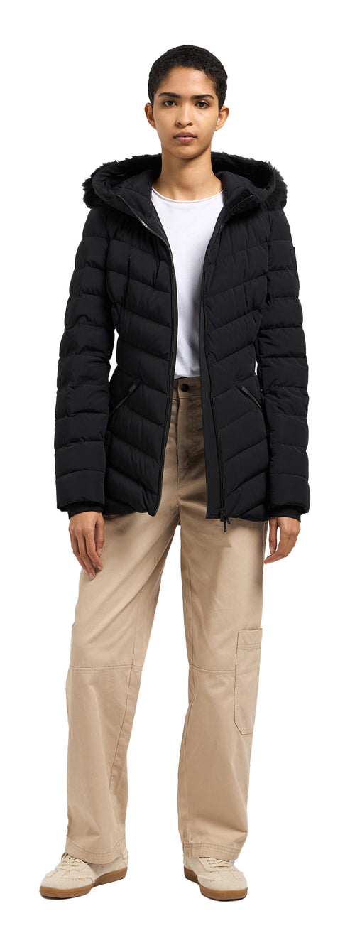 A person wearing a black puffer coat, a white shirt, and tan pants.