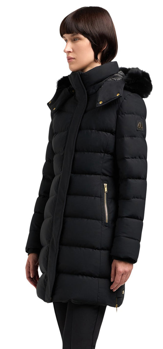 A woman wearing a black quilted parka with a fur-trimmed hood.