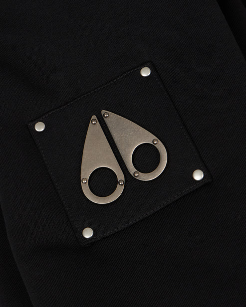 Close-up of a black patch with two metal tear-drop logos, each fixed with a small circular eye.