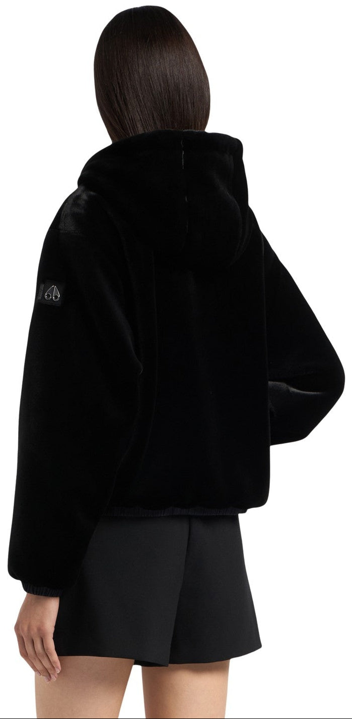 A black faux fur hooded jacket on a person.