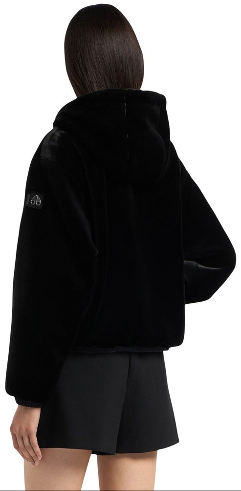 A black faux fur hooded jacket on a person.
