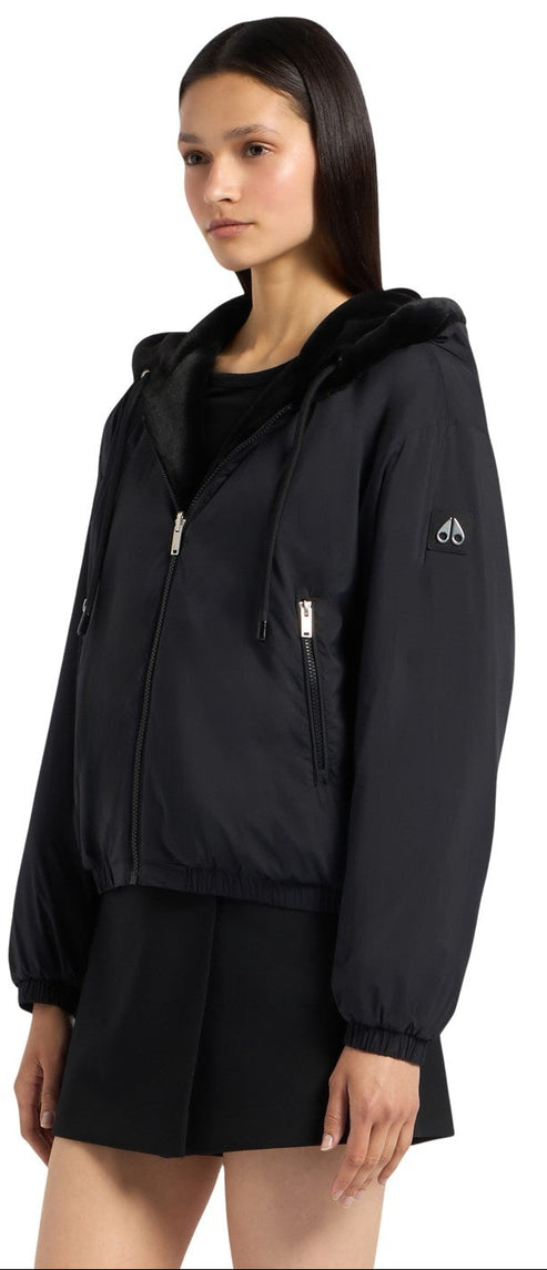 A woman in a black hooded jacket with a zipper.