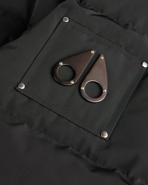 Close-up of a black garment featuring a square patch with rounded metal emblems.