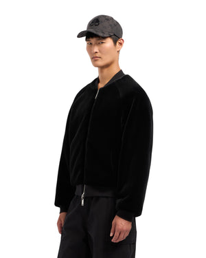 A man in a black jacket and cap.