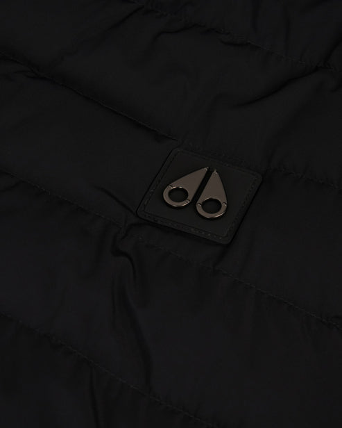 Close-up of black fabric with a small, square tag featuring two metallic, stylized moose knuckles.