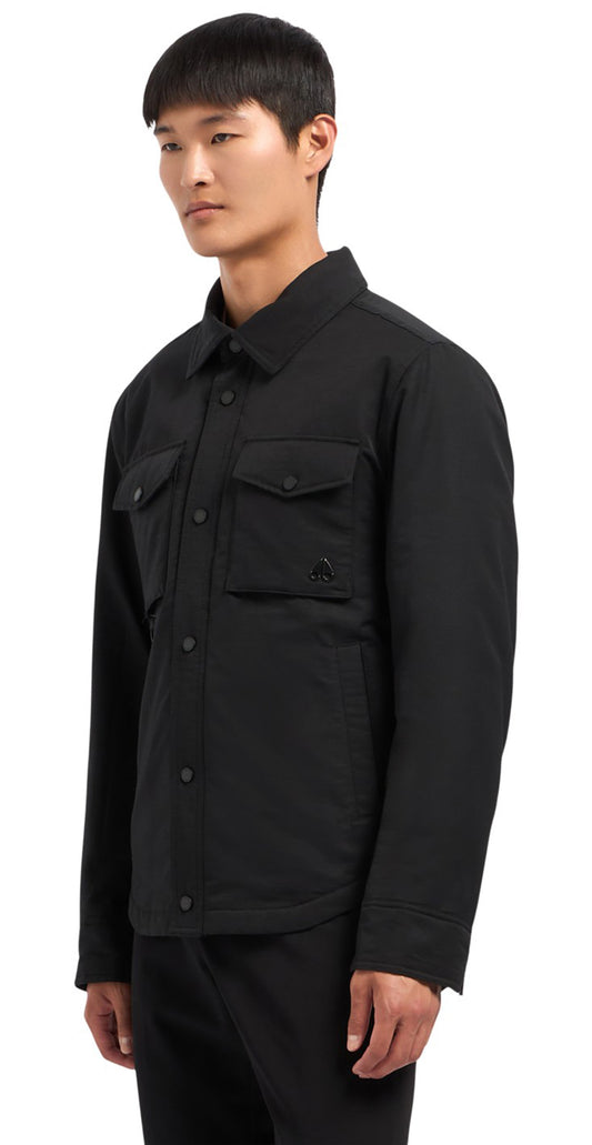 A male model stands wearing a black button down jacket with two chest pockets and a small logo on the right side.