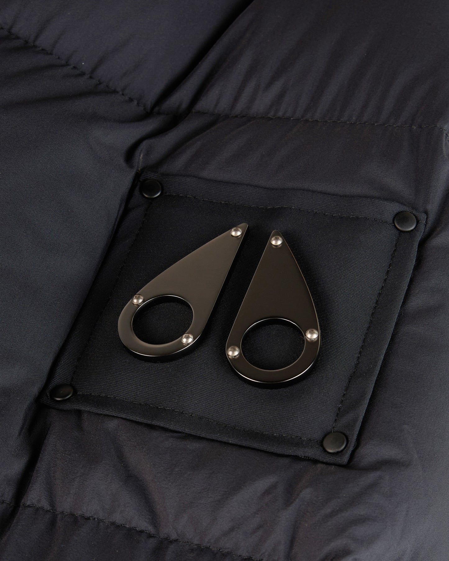 Close-up of black pocket with two teardrop-shaped metal accents.