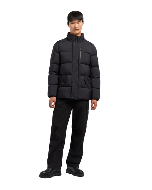 Man in black down puffer jacket and black pants.