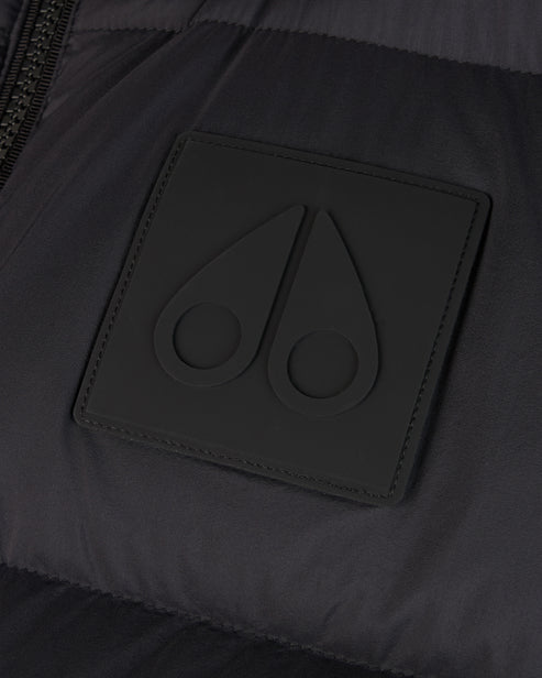 Close-up of a dark square patch with a subtle, raised emblem featuring two teardrop shapes with circular indents.