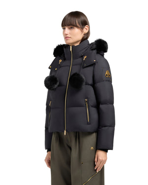 Black puffer jacket with fur hood and pom poms.