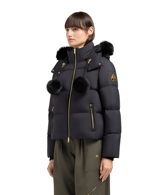 Black puffer jacket with fur hood and pom poms.