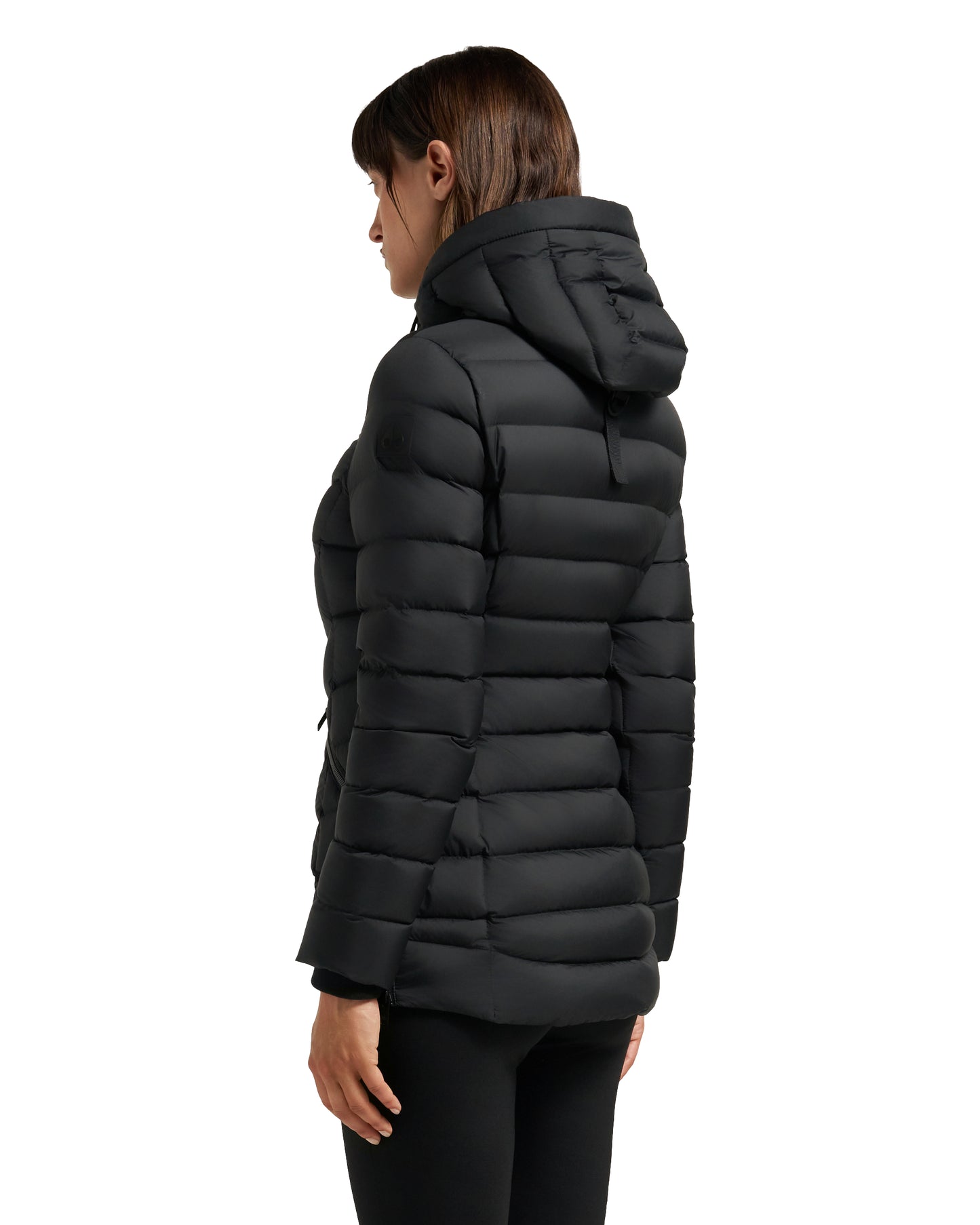 A woman wears a black, puffy, hooded jacket.