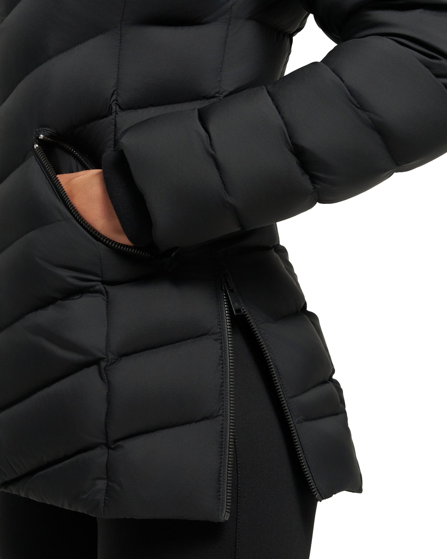 Close-up of a black quilted down jacket with a person's hand in a zippered pocket and a partially opened side zipper.