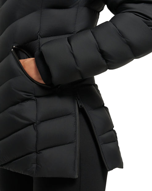 Close-up of a black quilted down jacket with a person's hand in a zippered pocket and a partially opened side zipper.