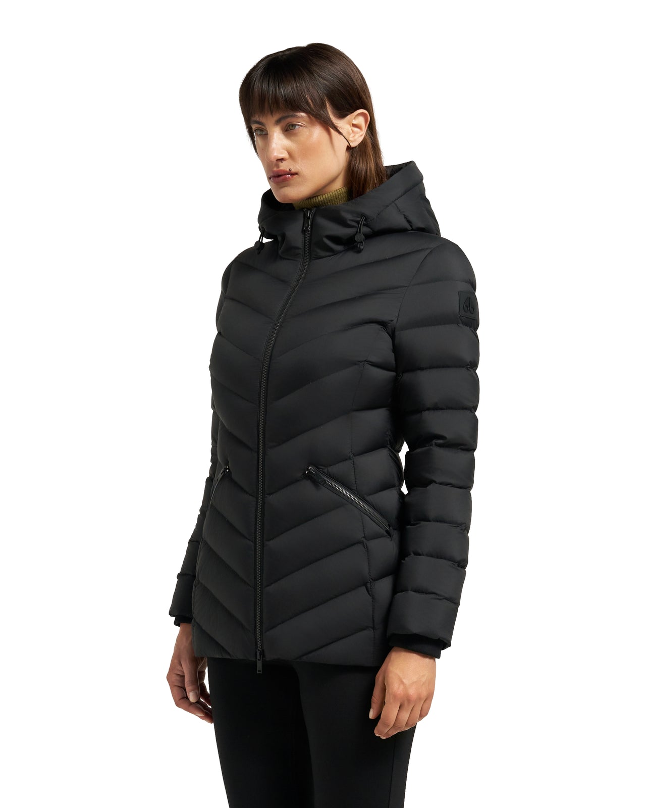 A woman models a black, hooded, quilted puffer jacket with a zipper closure.