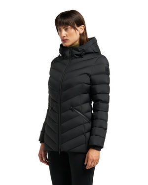 A woman models a black, hooded, quilted puffer jacket with a zipper closure.