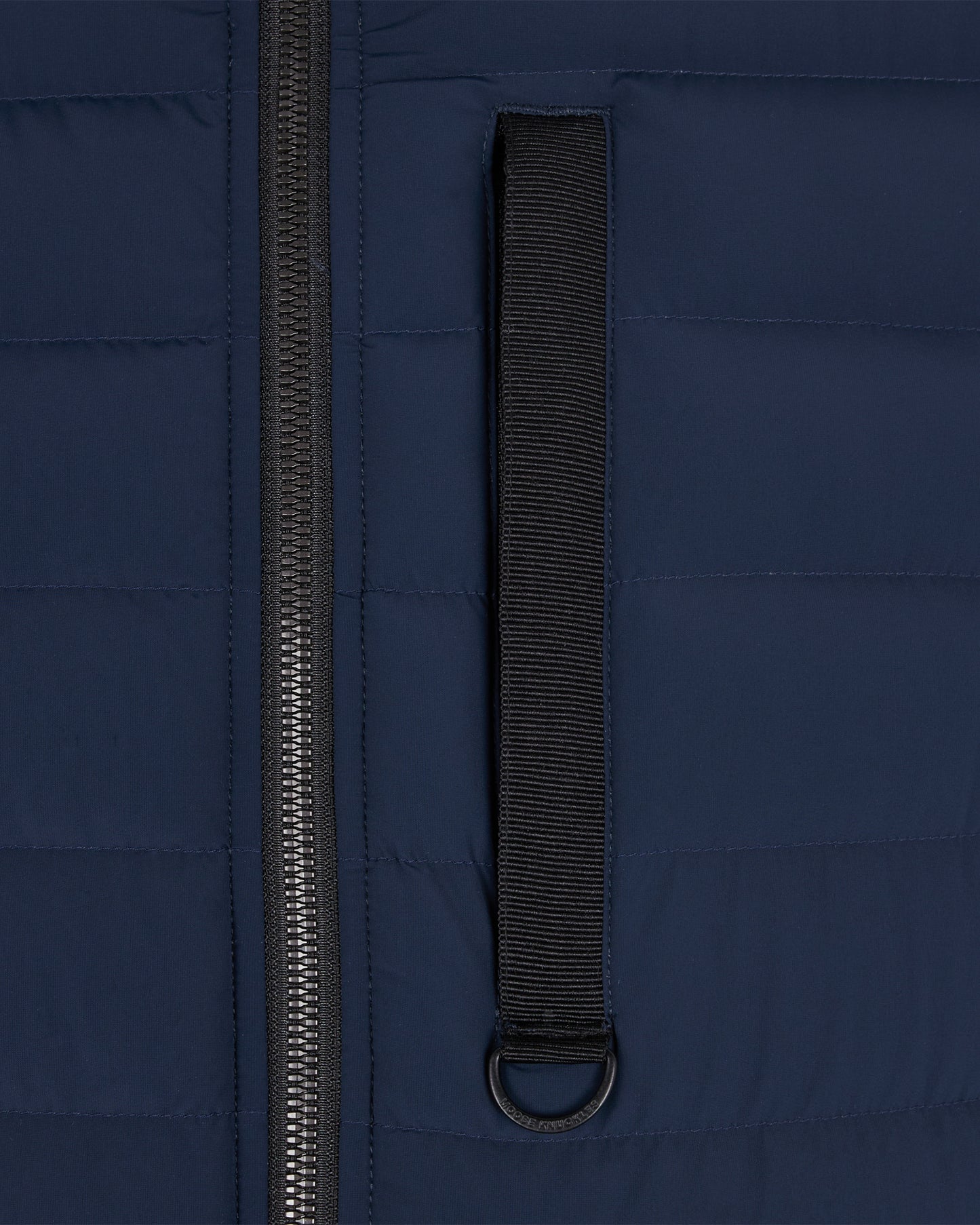 Navy blue puffer vest section with zipper and black strip with metal ring.